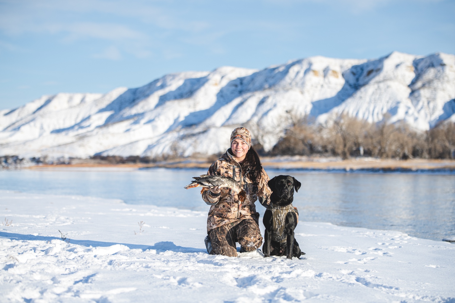 Hunter and Labrador in a snowy mountain setting